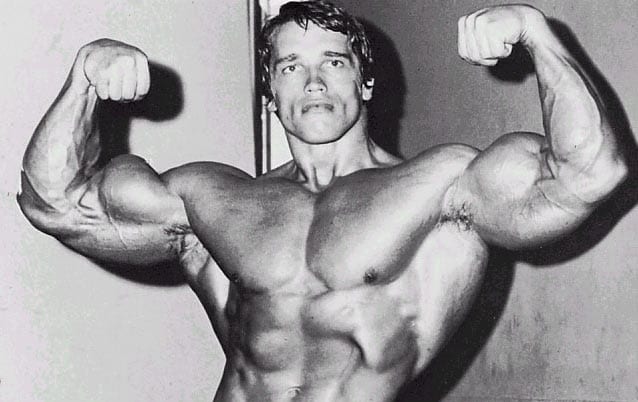 Image shows actor Arnold Schwarzenegger flexing his muscles.