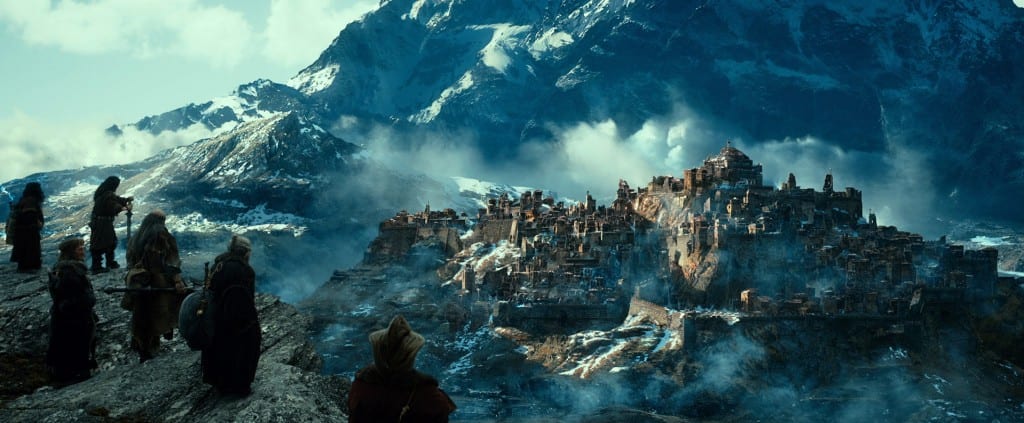 In the distance the ruins of a mountainside town can be seen, shrouded in smoke. 