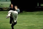Alan RIckman carries a discheveled Kate Winslet through a grassy field