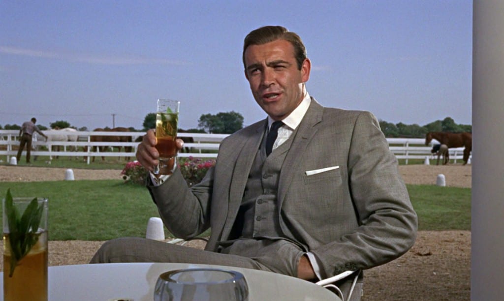 Sean Connery as James Bond, sitting in a chair drinking an alcoholic drink.