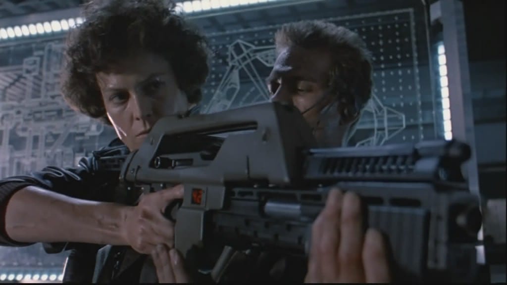 Image shows protagonist Ellen Ripley brandishes a Pulse Rifle in the movie Aliens.