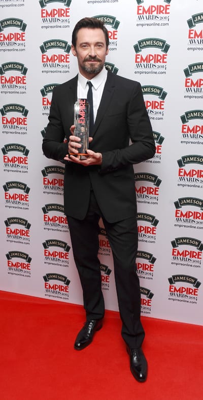 Hugh Jackman posing with his Empire Award in front of photographers.