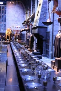 A long table set with plates cutlery and glasses on a sound stage at Leavesden Studios.