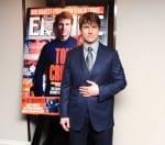 Tom Cruise standing in front of a large print of his Empire front cover