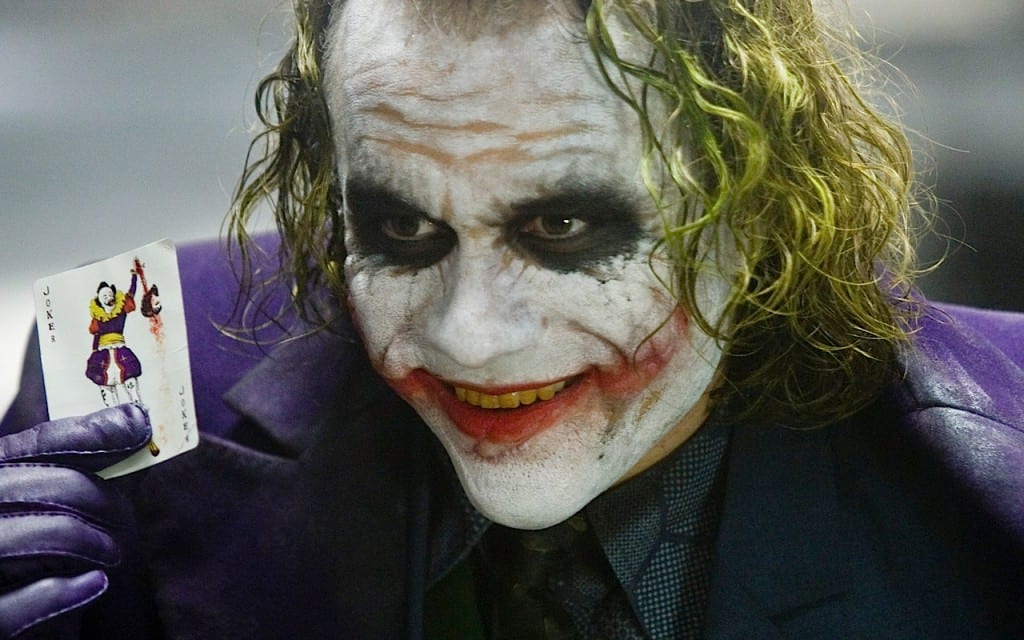 Heath Ledger's Joker holding a Joker playing card.